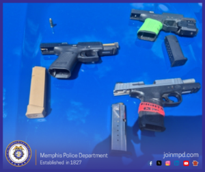 The image shows three handguns, several magazines, and one loose bullet displayed on a bright blue surface. At the bottom left corner is the Memphis Police Department seal. Along the bottom edge is text that reads “Memphis Police Department — Established in 1827” and “joinmpd.com,” along with several social media icons.