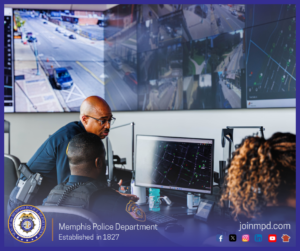 Inside a monitoring center, several individuals are seated at computer workstations with multiple screens displaying maps and data. One individual wearing a police uniform sits in front of a large monitor showing a grid-style map with highlighted points. Another individual stands close by, appearing to discuss or review the screen. In the background, a wall of large displays shows various aerial and street-level camera views of intersections and roadways. The Memphis Police Department emblem and the text “Memphis Police Department – Established in 1827” appear at the bottom left, while the website “joinmpd.com” and social media icons are shown at the bottom right within a blue border.