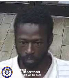 A person is shown from the shoulders up, wearing a light-colored collared shirt. The individual is positioned in front of a tiled or patterned vertical surface. In the lower‑left corner, a Memphis Police Department badge logo appears with text reading “Memphis Police Department CRIMESTOPPERS 901‑528‑CASH.”