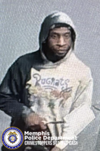 "Person wearing a hooded sweatshirt with a graphic design resembling characters from the show 'Rugrats.' The sweatshirt has light-colored sleeves and a darker-colored hood and shoulder area. The individual is holding an object near the midsection. In the lower-left corner, a Memphis Police Department CrimeStoppers badge and contact information are visible."