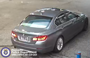 The image shows a gray BMW sedan from the rear/side in a parking lot, with tail lights illuminated and a visible license plate. The bottom-left corner includes Memphis Police Department / CrimeStoppers 901‑528‑CASH branding.