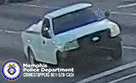 A small white pickup truck with a dark front grille is driving on a road with multiple painted lane lines. The truck’s bed appears empty, and the vehicle is slightly angled as it moves forward. In the lower left corner of the image is a Memphis Police Department badge graphic with accompanying text that reads “Memphis Police Department CRIMESTOPPERS 901‑528‑CASH.”