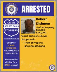 A rectangular poster with a blue and yellow design. At the top, a wide blue banner displays the word “ARRESTED” in large white letters. To the left of the banner is a circular seal labeled “City of Memphis Police Department.” Below this, on the left side of the poster, there is a large blue shield-shaped graphic with white text that reads: “CRIME STOPPERS 901‑528‑CASH.” Below the shield is the website “www.crimestopmem.org,” followed by additional text: “CONTACT CRIME STOPPERS ANONYMOUSLY 901‑528‑2274 You could be eligible for a CASH reward!” To the right of the shield graphic, there is a rectangular photo showing one individual standing in front of a height chart background. To the right of the photo, black text reads: “Robert Dishmon Theft of Property $60,000–$250,000 Robert Dishmon, 40, was charged with: • Theft of Property $60,000–$250,000” A small circular Memphis Police Department seal is placed in the bottom right corner of the poster.