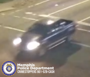 A blurred nighttime traffic camera image shows a dark-colored pickup truck traveling through an intersection. The truck has its headlights on and appears to be moving at a moderate speed. The vehicle has chrome side steps and lighter-colored paint along the lower portion of the body. The Memphis Police Department badge and the text “Memphis Police Department CRIMESTOPPERS 901-528-CASH” are displayed in the lower-left corner of the image.