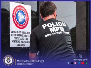 A person wearing a black shirt with large white text reading “POLICE MPD ORGANIZED CRIME” is seen from behind while placing or removing a lock or chain on a glass door. On the door, a posted notice displays the seal of the District Attorney General for Shelby County, Tennessee. The notice reads: “CLOSED BY ORDER OF THE ENVIRONMENTAL COURT AND THE DISTRICT ATTORNEY GENERAL.” The scene is framed with a Memphis Police Department graphic border. At the bottom left is the MPD seal with text stating “Memphis Police Department, Established in 1827.” At the bottom right is the website “joinmpd.com” along with several social media icons.